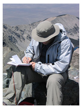 Kevin journaling on the summit